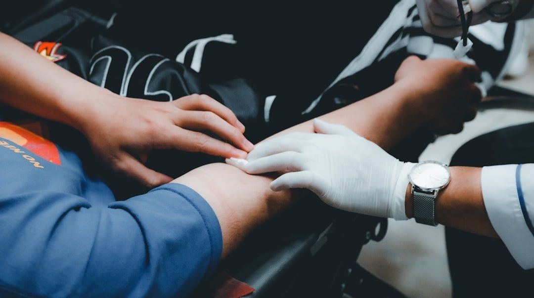 Handskar och händer undersöker en idrottares arm vid provtagning
